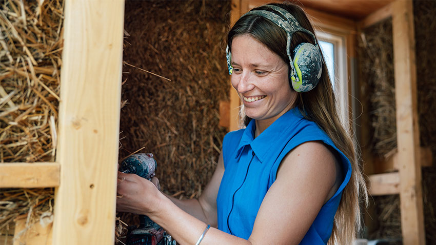 woman wearing ear protection works with power tool